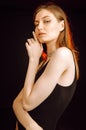 Young girl with wet, damp hair , big eyes and naked shoulders posing at dark red studio background Royalty Free Stock Photo