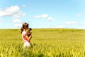 Young girl in wheat field holding dog contemplating the nature