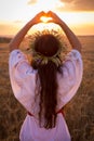 Young girl on wheat field making heart symbol