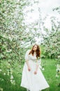 Young girl in a white dress and black hat in the in the white fl Royalty Free Stock Photo