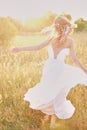 Young girl in a white dress in the meadow. Woman in a beautiful long dress posing in the garden. Stunning bride in a wedding dress Royalty Free Stock Photo