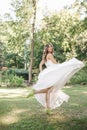 Young girl in a white dress in the meadow. Woman in a beautiful long dress posing in the garden. Stunning bride in a wedding dress Royalty Free Stock Photo