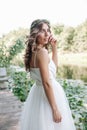 Young girl in a white dress in the meadow. Woman in a beautiful long dress posing in the garden. Stunning bride in a wedding dress Royalty Free Stock Photo