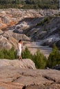 A young girl in white dress in the middle of a clay quarry.A beautiful woman on the background of beautiful landscape