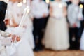 Young girl in white hold candle in hand at first holy communion