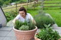 A young girl in a white T-shirt plant a tree in pot at home. Growing seedlings at home.