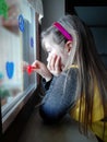 Worried Bored Little Girl Watching Outside of the Window