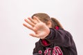 Young girl who don`t want to be photographed shielding her face with hand in foreground