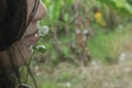 Young girl with a wild grass flower on her lip in the field. Royalty Free Stock Photo