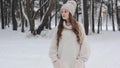 A beautiful girl is walking in a snow-covered forest
