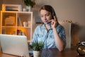 Young girl in wireless earphones talk on video call, have web conference with colleagues. Happy woman worker in headset watch