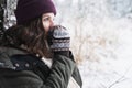 Young girl, woman in knitted mittens feels cold. Walking in beautiful winter forest among trees, firs, covered with snow. Royalty Free Stock Photo