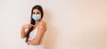 Young girl woman showing pointing with finger to bandage on her arm shoulder wearing protective mask done with vaccination. Female