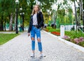 Young girl in a woolen sweater and torn jeans posing in an autumn park Royalty Free Stock Photo