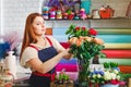 Young girl working in a flower shop, Florist woman makes a bouquet Royalty Free Stock Photo