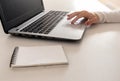 Young girl working with laptop, girl`s hands typing on notebook computer, business woman telecommuting, working remotely at home Royalty Free Stock Photo