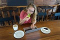 The young girl works at the computer and cake, food at the computer, a bad habit eats. Royalty Free Stock Photo