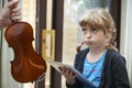 Young Girl Would Rather Play On Digital Tablet Than Practise Violin