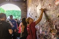 Young girl write a letter to Juliet on the wall in the passage to Juliet house in Verona, Italy Royalty Free Stock Photo