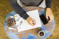 Young girl writes in a notebook with cell phone, cup of coffee a Royalty Free Stock Photo