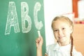 Young girl writing ABC on green chalkboard Royalty Free Stock Photo