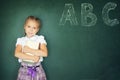 Young girl writing ABC on green chalkboard Royalty Free Stock Photo