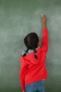 Young girl writing on chalk board