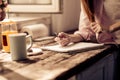 Young girl writing in notebook in the kitchen. Royalty Free Stock Photo