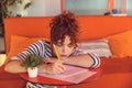 Young girl writing something and looking tired and bored Royalty Free Stock Photo