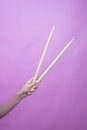 young girl& x27;s hands are holding drum sticks on pink background Royalty Free Stock Photo