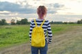 Young girl with yellow backpack, back, , evening sunset sky Royalty Free Stock Photo