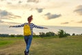 Young girl with yellow backpack, her back with open hands Royalty Free Stock Photo