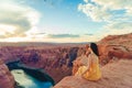 Beautiful woman in yellow dress on the edge of the cliff at Horseshoe Band Canyon in Paje, Arizona. Beautiful nature in