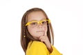 Young girl in yellow glasses posing with finger on cheek