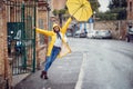 A young girl with yellow raincoat and umbrella is having a good time while walking the city on the rain. Walk, rain, city Royalty Free Stock Photo