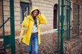 A young girl in yellow raincoat walking through the city on the rain. Walk, rain, city Royalty Free Stock Photo