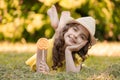 A young girl in a yellow suit and a hat with a lollipop in her hands outdoors in the park Royalty Free Stock Photo