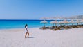 young girlon the beach of Mykonos, Elia beach Mikonos, Mykonos beach during summer with umbrella and luxury beach chairs