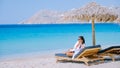 young girlon the beach of Mykonos, Elia beach Mikonos, Mykonos beach during summer with umbrella and luxury beach chairs