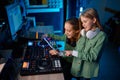 Young girls adjusting sound on sound mixer in radio station