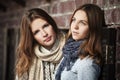 Young fashion girls against a brick wall Royalty Free Stock Photo