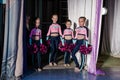 Young girls - athletes are preparing for the show, many young cheerleaders are standing on stage behind the curtain, sportsmen are Royalty Free Stock Photo