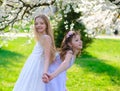 Young girls with blue eyes in white dresses in garden with apple trees blosoming Royalty Free Stock Photo