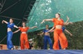 Young girls in bright suit dance and show acrobatic stunts on sc