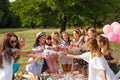 Young girls cheers on picnic party at nature