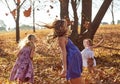 Young girls children kids playing running in fallen autumn leave