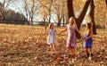 Young girls children kids playing running in fallen autumn leave Royalty Free Stock Photo