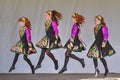 Young girls in colorful costumes performing an Irish dance