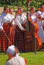 Young girls enjoy playing musical instrument during Latvian outdoor Folk Festival at Turaida field, Latvia
