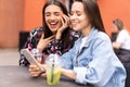 Young girls friends watch something in smartphone. Royalty Free Stock Photo